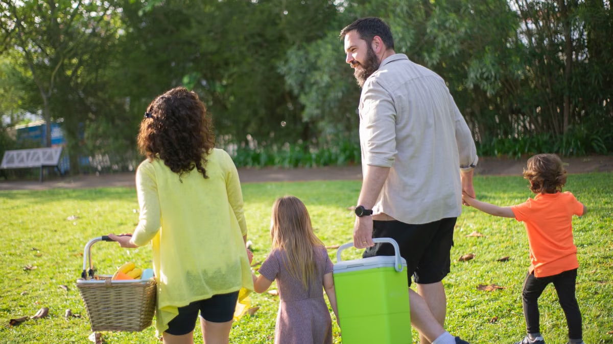A family of four enjoys a picnic in a sunny park, capturing a joyful day outdoors.
